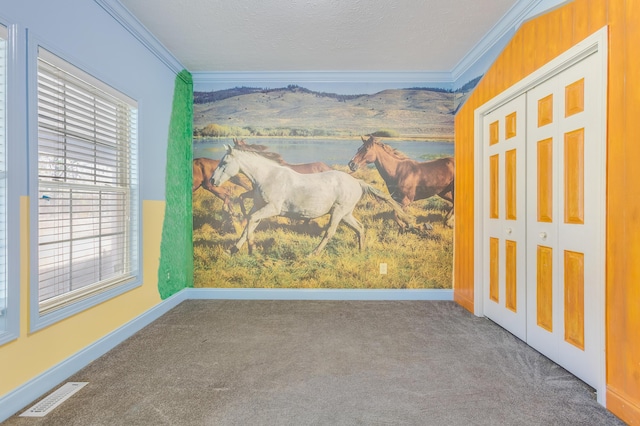 carpeted spare room with visible vents, baseboards, a textured ceiling, and crown molding