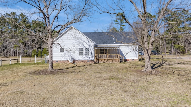 rear view of house featuring fence, a lawn, roof with shingles, and crawl space