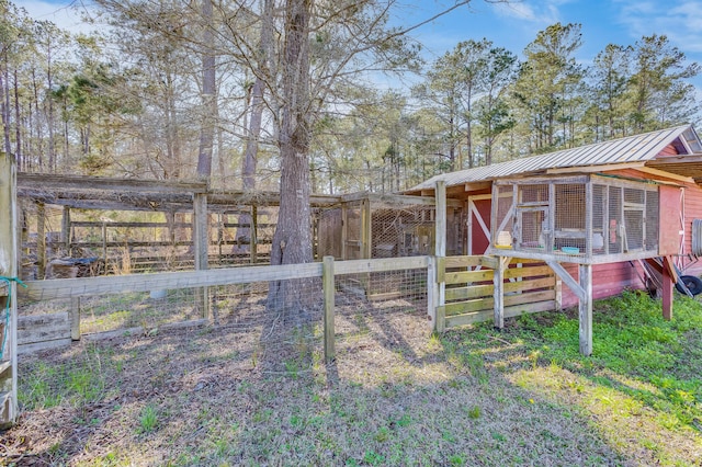 view of yard featuring an outdoor structure, fence, and exterior structure