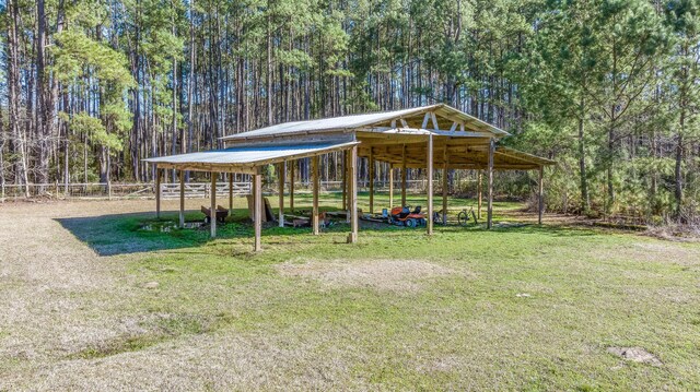 view of yard featuring a carport and a view of trees