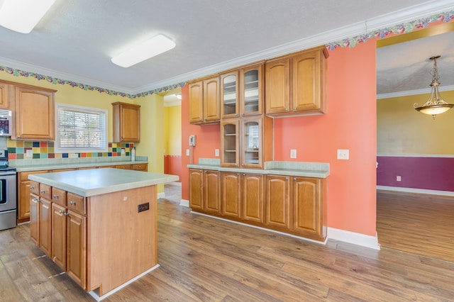 kitchen featuring brown cabinetry, crown molding, and wood finished floors