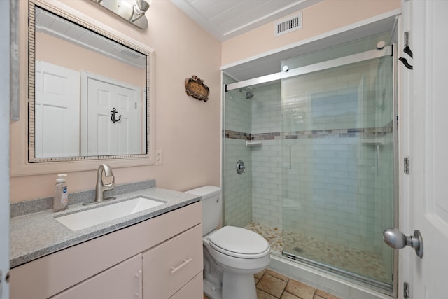 bathroom featuring toilet, a shower with door, and vanity