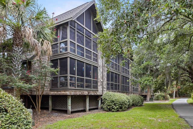 back of property with a yard and a sunroom