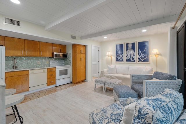 kitchen featuring white appliances, tasteful backsplash, beamed ceiling, and sink