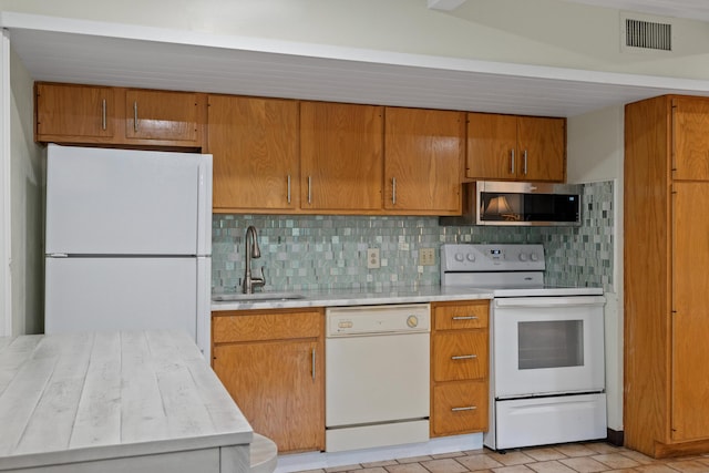 kitchen with white appliances, backsplash, and sink