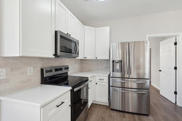 kitchen featuring appliances with stainless steel finishes, decorative backsplash, dark hardwood / wood-style flooring, and white cabinetry