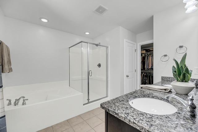 bathroom featuring a spacious closet, visible vents, a shower stall, a garden tub, and tile patterned floors