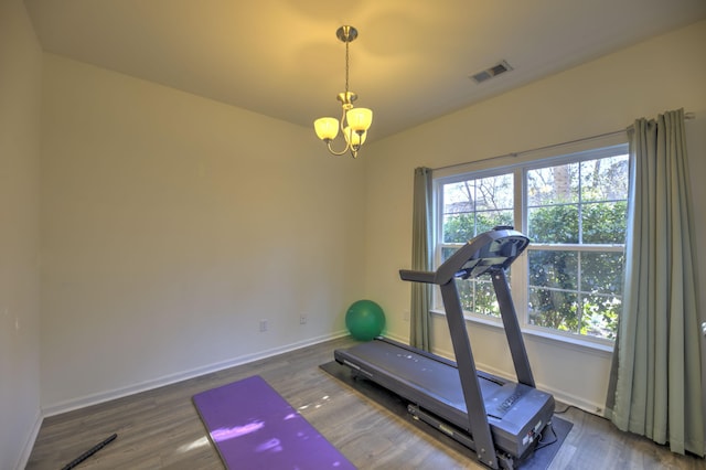 workout area featuring visible vents, a healthy amount of sunlight, baseboards, and wood finished floors