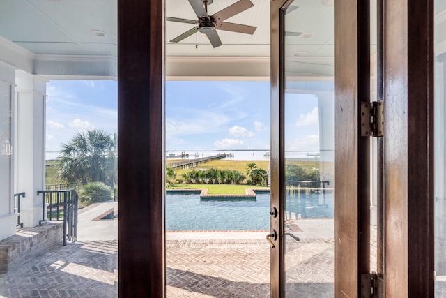 doorway to outside featuring a water view, ceiling fan, and ornamental molding