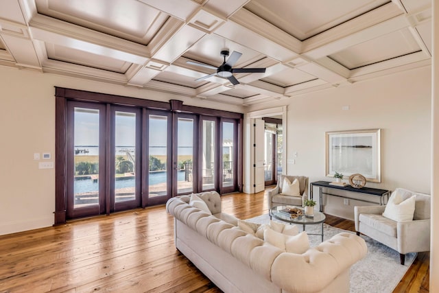 living room with light hardwood / wood-style floors, coffered ceiling, and ceiling fan