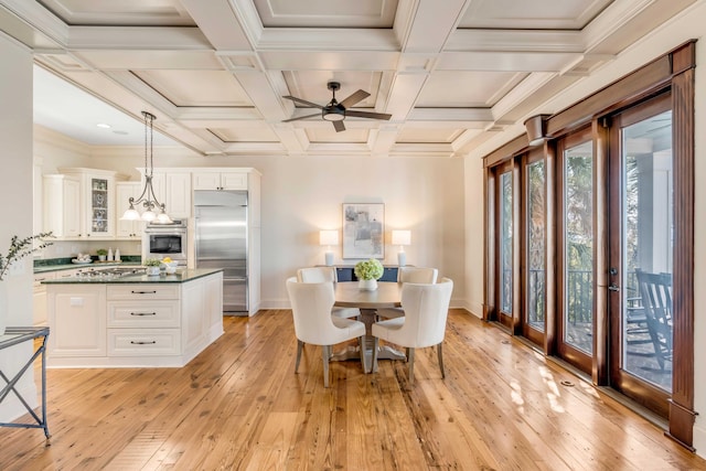 dining area with ceiling fan, coffered ceiling, beamed ceiling, crown molding, and light hardwood / wood-style flooring