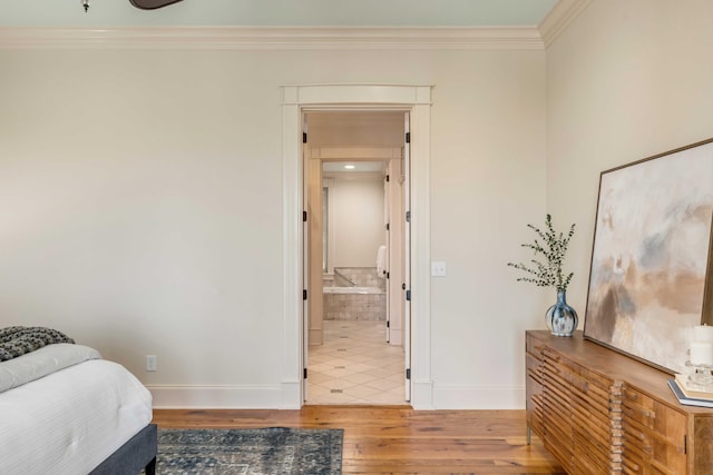 bedroom with ensuite bath, hardwood / wood-style flooring, and ornamental molding