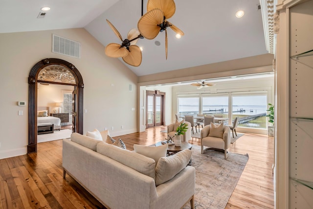 living room with hardwood / wood-style flooring, high vaulted ceiling, and ceiling fan