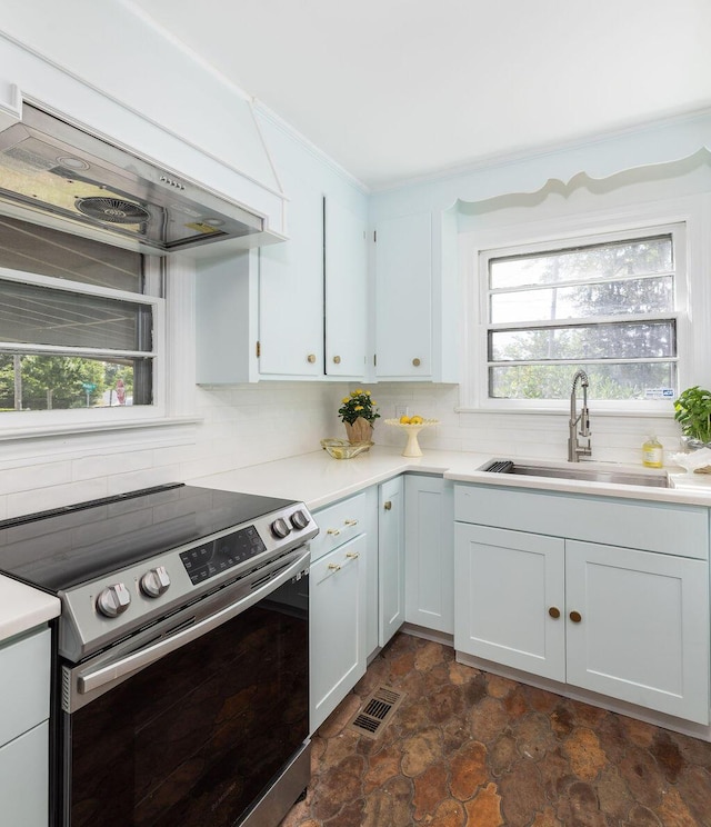 5065 Durant Ave, North Charleston, SC 29405 - kitchen with electric range, custom range hood, backsplash, and healthy amount of natural light