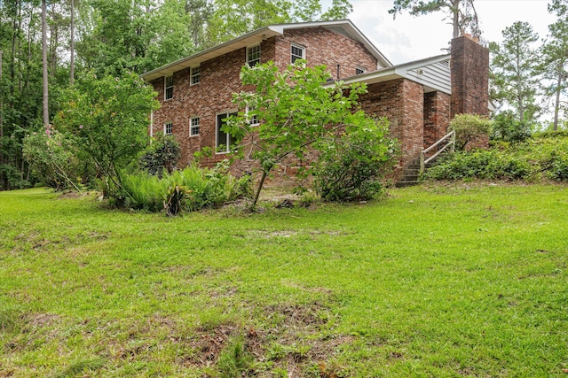 1019 Pinon Rd, North Augusta, SC 29841 - view of home's exterior featuring a chimney, brick siding, and a lawn