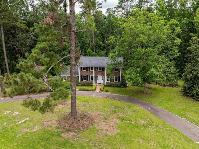 1019 Pinon Rd, North Augusta, SC 29841 - view of front facade with curved driveway, a front lawn, brick siding, and a forest view