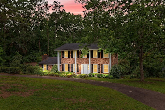 1019 Pinon Rd, North Augusta, SC 29841 - greek revival house featuring a front yard, brick siding, a chimney, and driveway