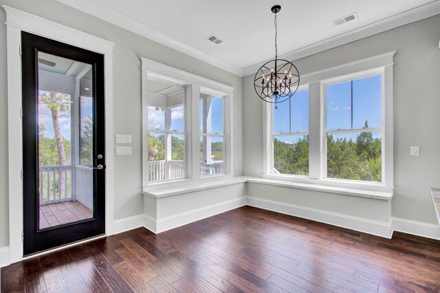 unfurnished dining area with crown molding, a chandelier, and dark hardwood / wood-style floors