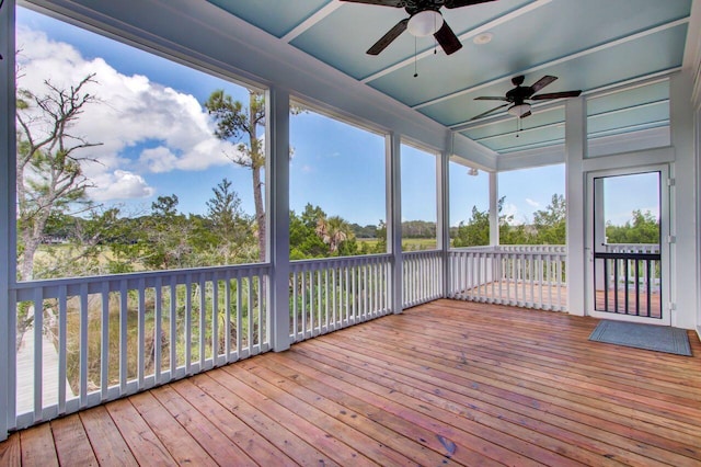 unfurnished sunroom featuring ceiling fan and a wealth of natural light