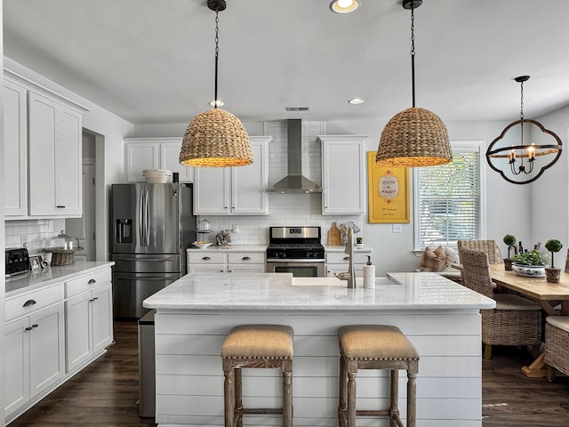 3381 Stockdale St, Mount Pleasant, SC 29466 - kitchen featuring appliances with stainless steel finishes, wall chimney range hood, decorative backsplash, a chandelier, and white cabinets