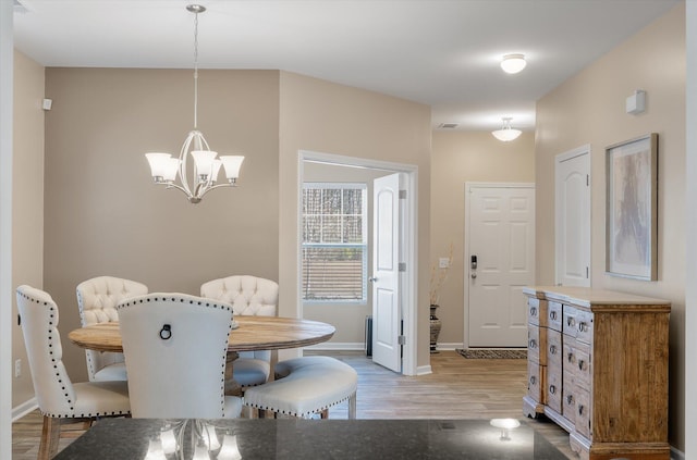 dining room featuring an inviting chandelier and hardwood / wood-style flooring