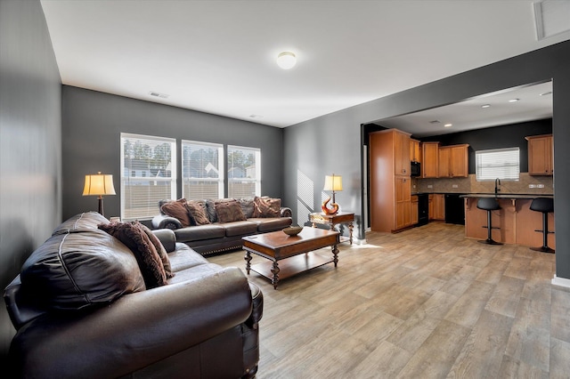 living room with sink and light hardwood / wood-style floors