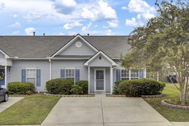 view of front of home featuring roof with shingles and a front yard