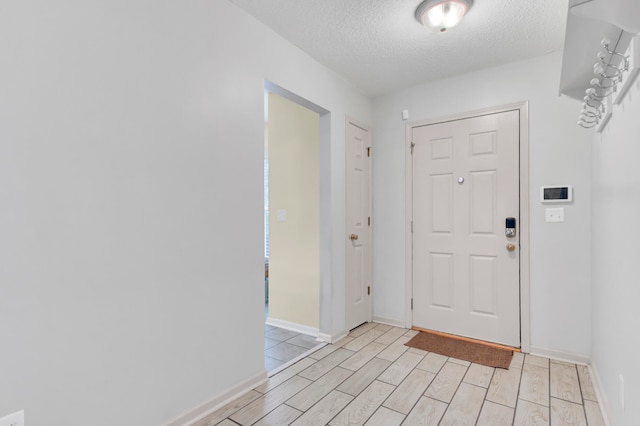 foyer with a textured ceiling and light hardwood / wood-style floors