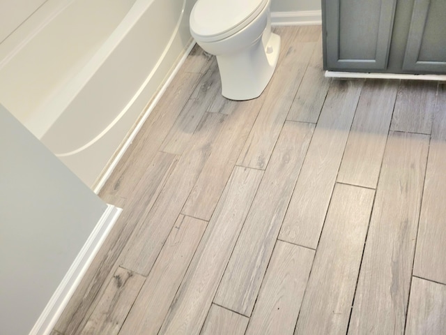 details featuring hardwood / wood-style floors and toilet