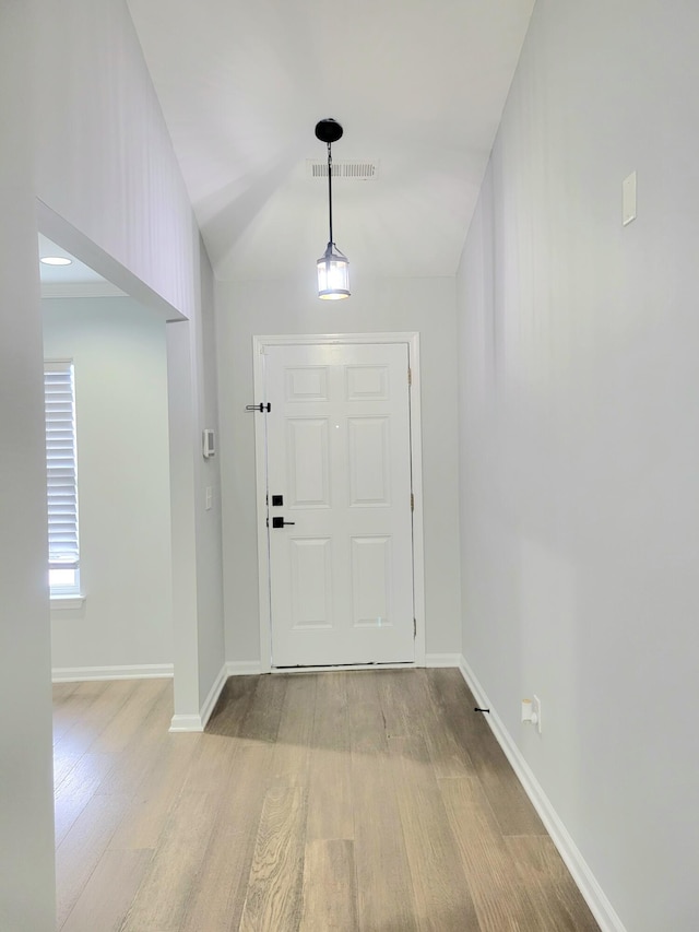 foyer entrance with light hardwood / wood-style floors and vaulted ceiling