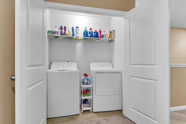 laundry area featuring light hardwood / wood-style floors and washing machine and clothes dryer