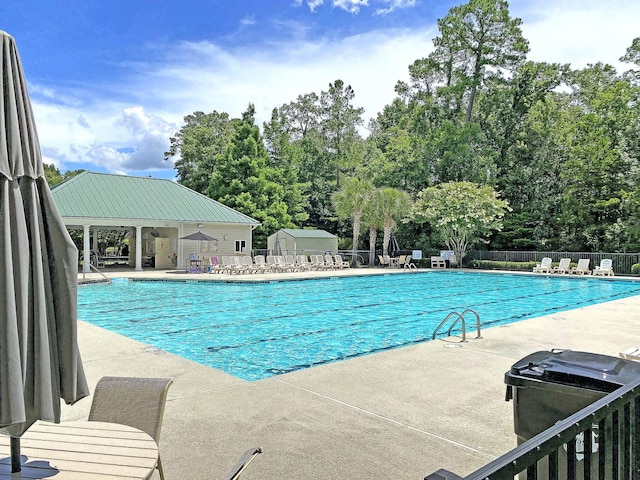 view of swimming pool featuring a patio and an outdoor structure