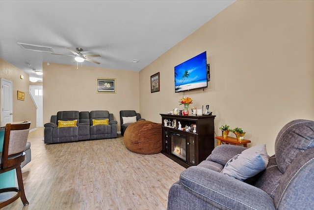 living room featuring light hardwood / wood-style flooring and ceiling fan