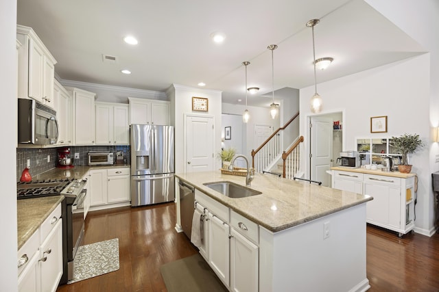 kitchen featuring light stone countertops, stainless steel appliances, sink, pendant lighting, and dark hardwood / wood-style floors