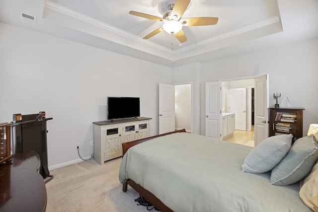 bedroom featuring ensuite bath, ceiling fan, light colored carpet, a tray ceiling, and ornamental molding