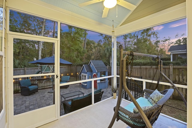 sunroom / solarium with ceiling fan and lofted ceiling