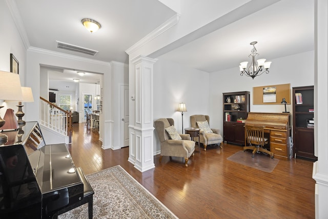 interior space with dark hardwood / wood-style floors, ornate columns, crown molding, and a notable chandelier