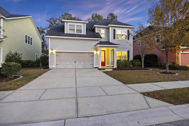 view of front facade with a yard and a garage