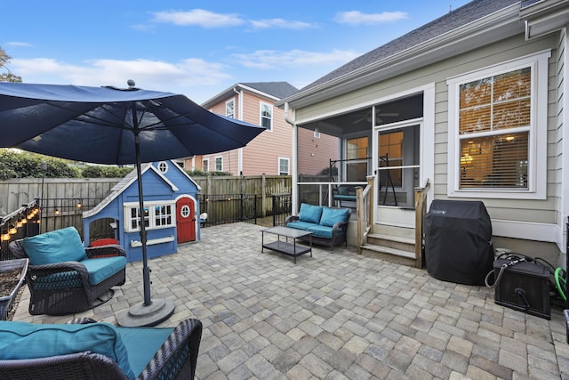 view of patio / terrace featuring an outdoor structure, grilling area, a sunroom, and an outdoor hangout area