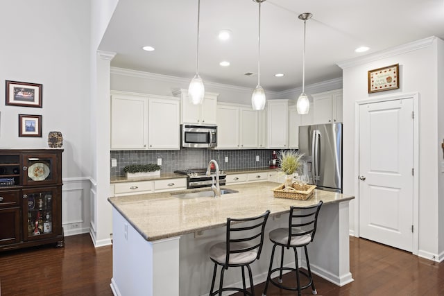 kitchen featuring white cabinets, pendant lighting, stainless steel appliances, and sink