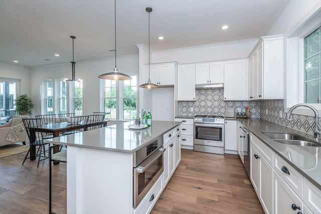 kitchen featuring dark hardwood / wood-style floors, pendant lighting, white cabinets, and appliances with stainless steel finishes