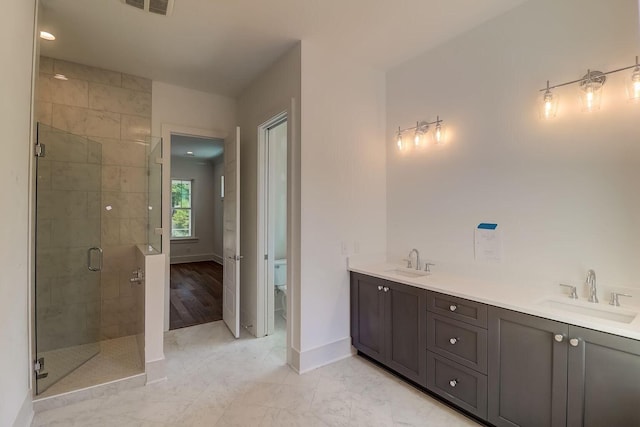 bathroom with a shower with door, tile flooring, dual vanity, and toilet