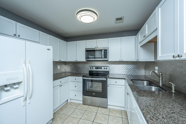 kitchen featuring appliances with stainless steel finishes, tasteful backsplash, white cabinetry, and sink