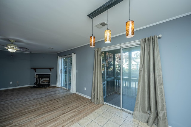 unfurnished living room featuring light wood-type flooring, plenty of natural light, crown molding, and ceiling fan