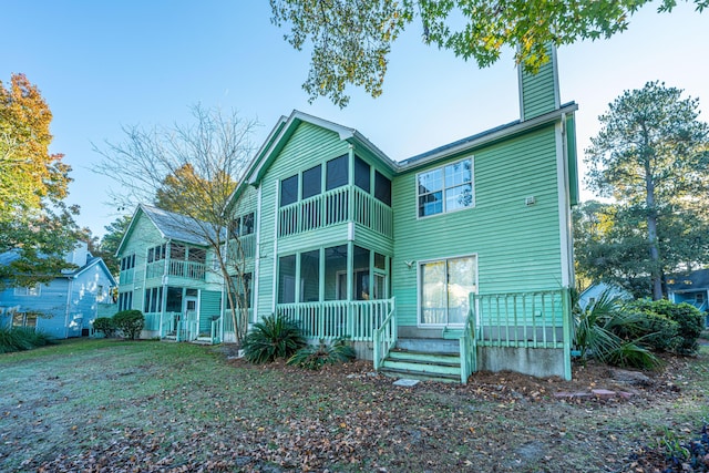 rear view of property featuring a porch and a balcony