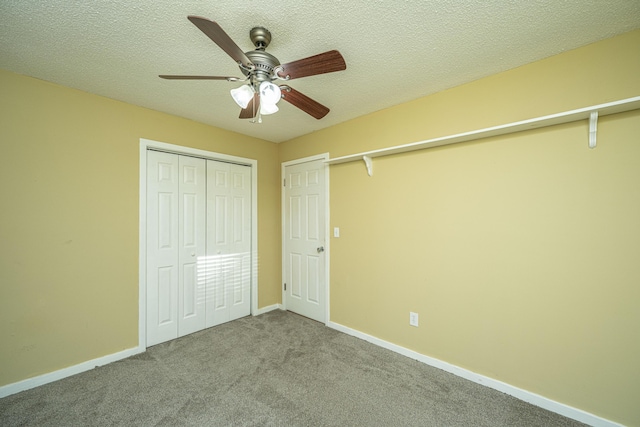 unfurnished bedroom with ceiling fan, light colored carpet, and a textured ceiling