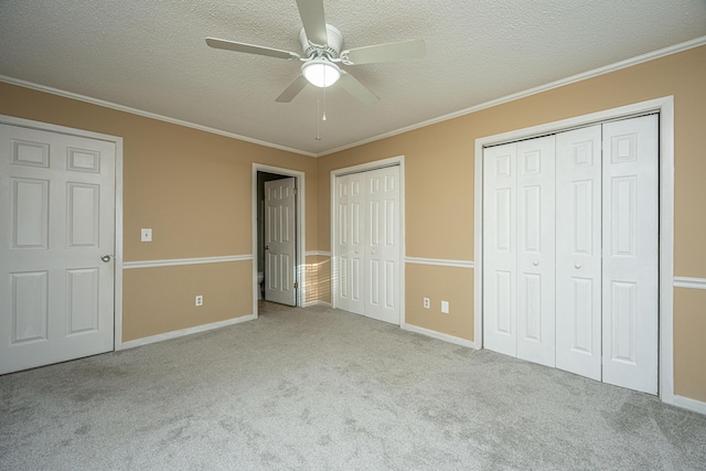 unfurnished bedroom featuring ceiling fan, light carpet, and two closets