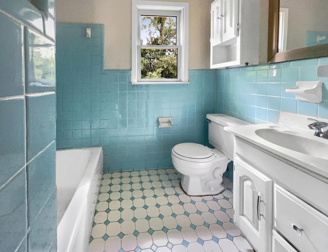 bathroom featuring vanity, tile walls, toilet, and a tub