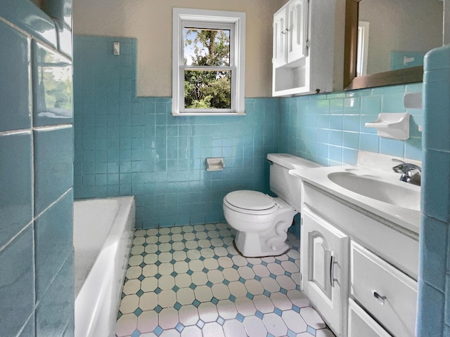 bathroom with a wainscoted wall, toilet, a washtub, tile walls, and vanity