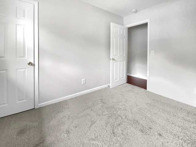 unfurnished room featuring carpet flooring and baseboards